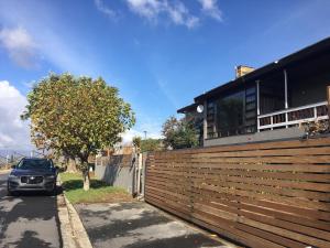 a car parked next to a fence in front of a house at A' Queenslin Guesthouse in Paarl