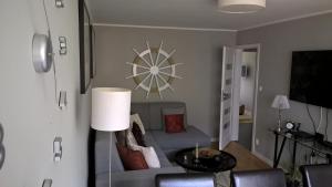 salon z kanapą i zegarem na ścianie w obiekcie No.1 Apartments - Kołobrzeg Beach Centrum w Kołobrzegu