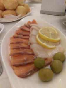 a plate of fish with lemon slices and grapes at Эдельвейс in Almaty