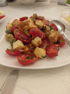 um prato de comida com tomates numa mesa em Эдельвейс em Almaty