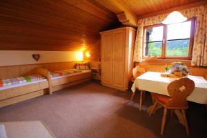 a bedroom with a table and a bed and a window at Heachhof in Alpbach