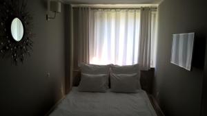 sypialnia z łóżkiem z poduszkami i oknem w obiekcie No.1 Apartments - Kołobrzeg Beach Centrum w Kołobrzegu