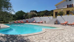 una piscina con tumbonas y un edificio en Il Sogno di Alghero - Adults Only, en Alghero