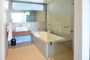 a bathroom with a tub and a sink and a shower at 214 Harbour Bridge in Cape Town +25 photos