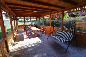 una veranda riparata con panchina e tavoli di Casa Iustina Sulina a Sulina