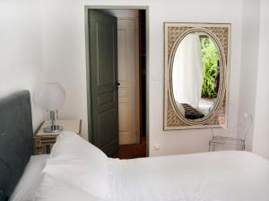 a bedroom with a bed and a mirror at Hôtel La Villa Sainte Valérie Adults Only in Juan-les-Pins