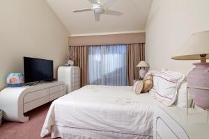 a bedroom with a white bed and a flat screen tv at Palm Valley Country Club, Pickleball, Tennis, Gym, Clubhouse, Swimming Pools, Lux, Spac 2 Bdrms Den 2 Ba in Palm Desert