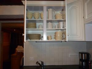 a kitchen cabinet filled with cups and saucers at Le Mazot in Villaroger