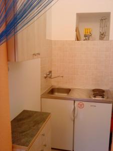 a small kitchen with a sink and a refrigerator at Apartmani Loreta in Mali Lošinj