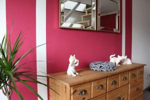 una habitación con espejo y dos gatos en un tocador en Ferienwohnung zum Nordlicht, en Bassum