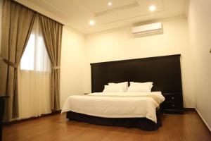 um quarto com uma cama grande e uma janela em Sama Al Nakheel Furnished Apartments-Families only em Riyadh