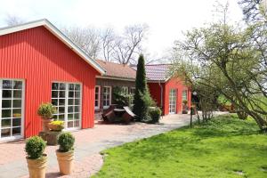 ein rotes Haus mit einem Innenhof davor in der Unterkunft Katrins Ferienhof in Wüppels