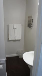 a bathroom with a white sink and towels on a wall at Atlantic Sands in Hampton +14 photos