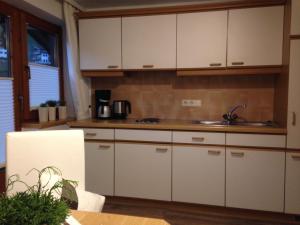 a kitchen with white cabinets and a sink at Apartment Theresia in Schwendau