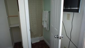 a small bathroom with a shower and a white door at Atlantic Sands in Hampton