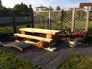 a wooden bench and a chair on a deck at Kevade Guesthouse with Sauna in Kuressaare
