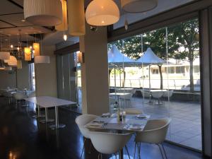 a restaurant with tables and chairs and large windows at 214 Harbour Bridge in Cape Town