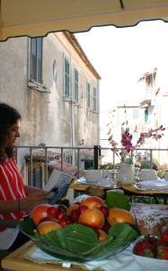 una persona sentada en una mesa con un montón de fruta en B&B Residenza Cardinale, en Tropea