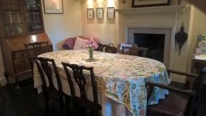 a dining room table with a vase of flowers on it at Thorpe Green House Vegetarian Bed & Breakfast in Robin Hood's Bay