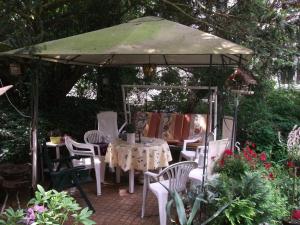 einen Pavillon mit einem Tisch und Stühlen im Garten in der Unterkunft Pension und Ferienwohnung Christine Kilian in Eisenach