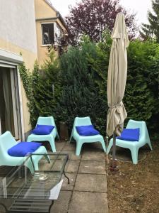 un patio con 2 sillas azules y una sombrilla en Chateau Joe, en Viena