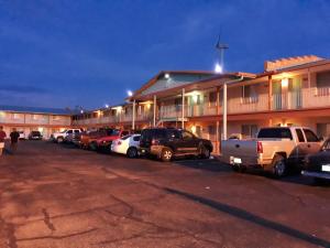 un parcheggio con auto parcheggiate di fronte a un motel di Tristar Inn Xpress a Tucumcari