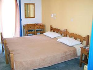 a bed room with two beds and a table at Panorama Hotel in Kalymnos