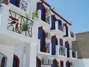 a white building with blue and red windows at Panorama Hotel in Kalymnos