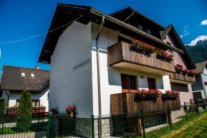 un bâtiment avec des boîtes de fleurs et des balcons. dans l'établissement Apartments and Holiday Home Grohar, à Kranjska Gora