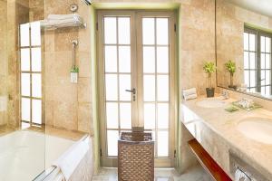 a bathroom with a tub and a sink at Hotel Los Itzaes by 5th av in Playa del Carmen