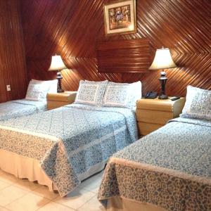 a hotel room with two beds and two lamps at Hotel Cafe in Jinotega