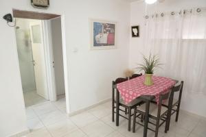 a dining room with a table with a vase on it at Dead Sea Yehuda Apartments in Arad