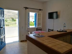 a room with a kitchen with a table and a window at House near Sea in Gavrio