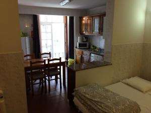 Cette petite chambre comprend un lit et une cuisine avec une table. dans l'établissement Downtown PORTO SE, à Porto