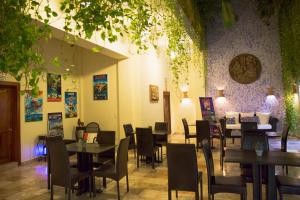 um restaurante com mesas e cadeiras num quarto em Hotel Los Itzaes by 5th av em Playa del Carmen