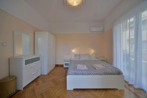 A bed or beds in a room at Oasis veranda under columns.Kolonaki embassy area.