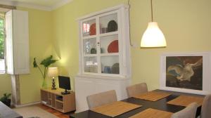 a dining room with a table and a cabinet with a window at Foz Gardens in Porto