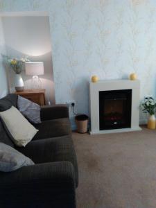 a living room with a couch and a fireplace at Howe Holiday homes in Stromness