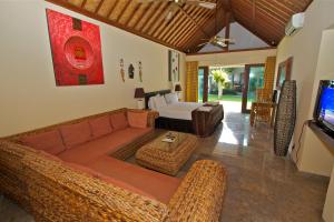 a living room with a couch and a bed at Bayshore Villa in Candidasa