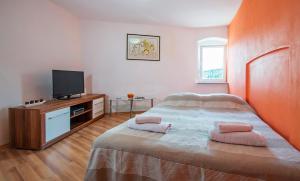 a bedroom with a bed with pink towels on it at Karla Apartment in Labin