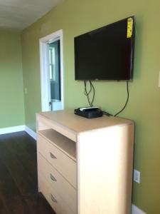 a television on top of a dresser in a room at Hollywood Motel in New Castle
