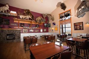 un restaurante con mesas, sillas y perros en la pared en Ninepipes Lodge en Polson