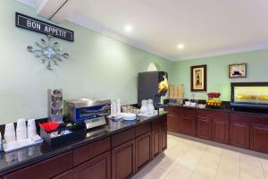 a restaurant with a counter with a coffee maker at Travelodge by Wyndham Orange County Airport/ Costa Mesa in Costa Mesa