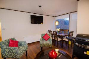 Departamento Andes Chillan في Nevados de Chillan: غرفة معيشة مع طاولة وكراسي وتلفزيون