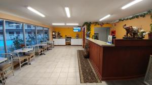 a restaurant with a bar and tables and chairs at Best Budget Inn Tell City in Tell City