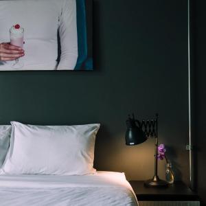 a bed with a picture of a person holding a candle at J Poshtel Chiangmai in Chiang Mai