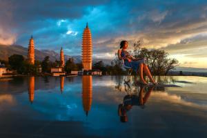 a woman sitting in a chair next to a pool of water at Dali Rong Hotel in Dali