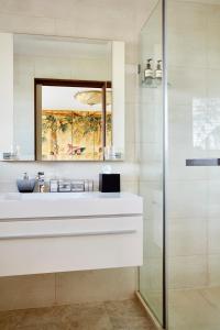 y baño con lavabo blanco y espejo. en The Church House Gourmet Retreat en Fish Creek