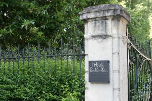 a stone pillar with a sign on it next to a fence at L'Hôtel Particulier - Appartements d'Hôtes in Nancy