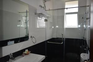 a bathroom with a shower and a sink and a mirror at Tranquil Villa in Nuwara Eliya +39 photos